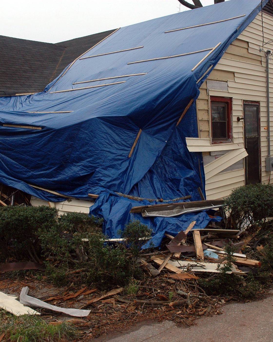 A storm-damaged house under a blue tarp in Cabbagetown, Atlanta