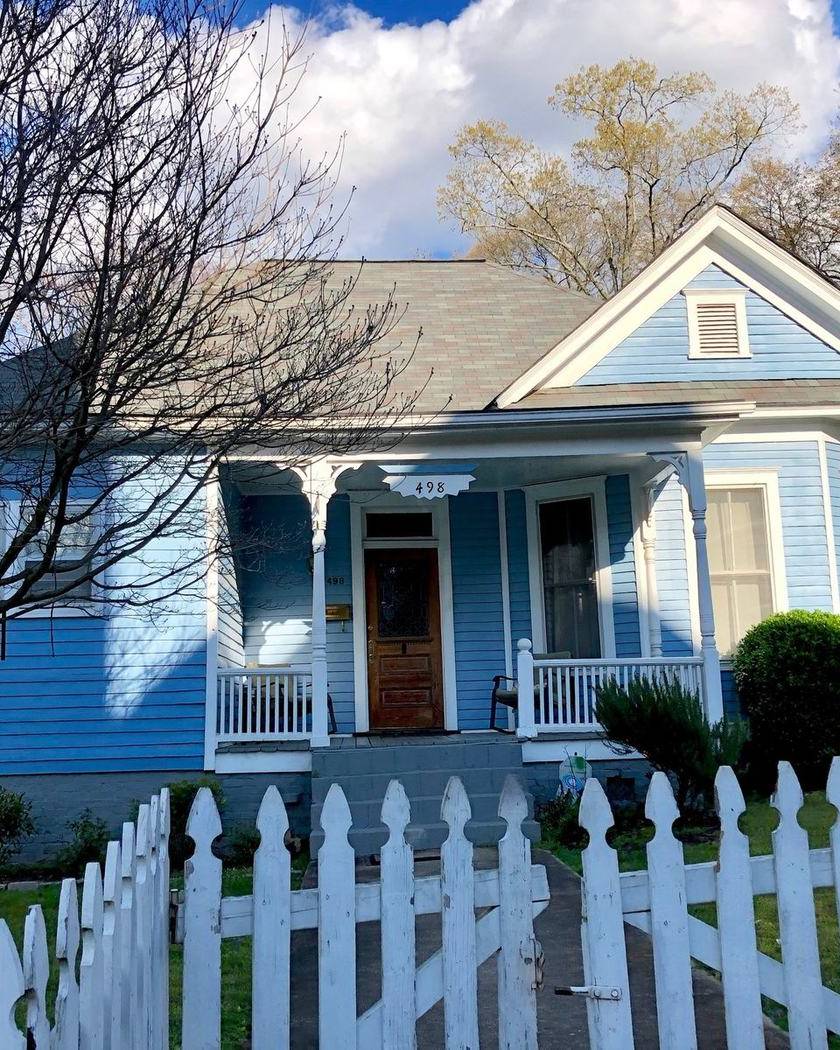 A blue house behind a white picket fence in Grant Park, Atlanta