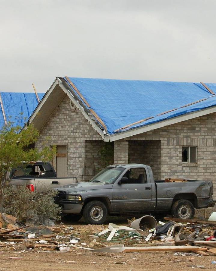 Blue tarps covering storm-damaged roofs