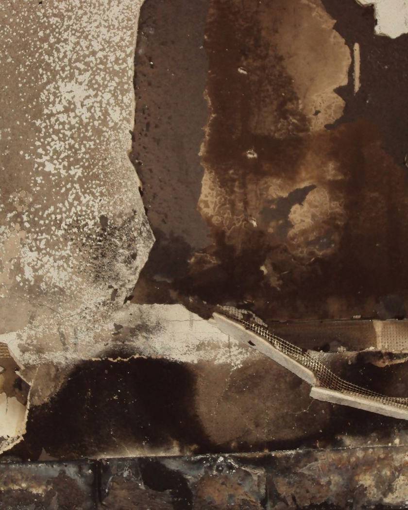 A wall charred and blistered by fire
