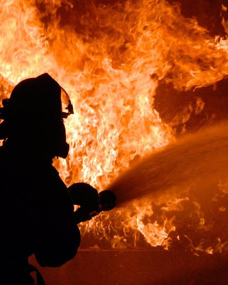 A firefighter sprays water into flames