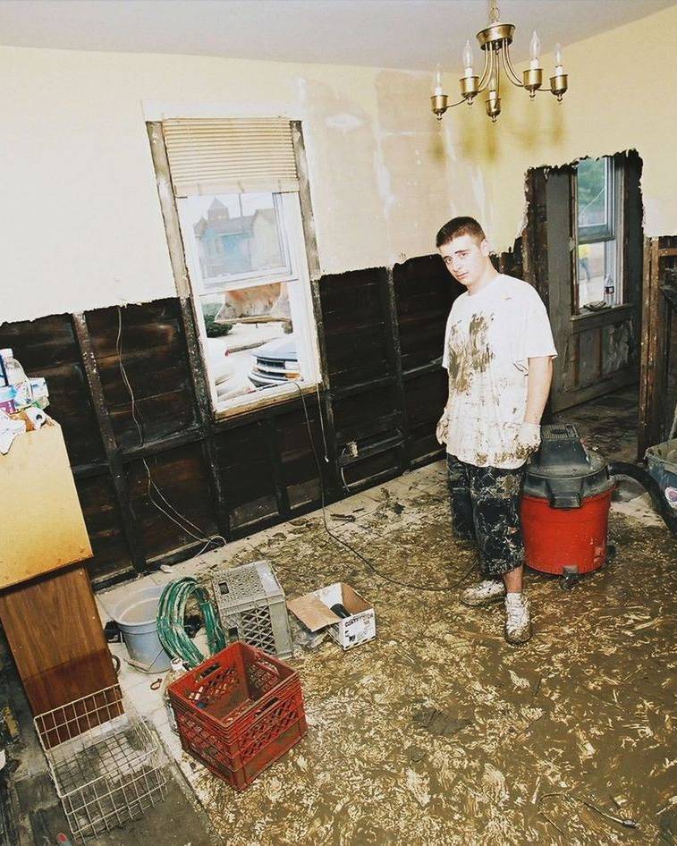 A man clears out a water-damaged room