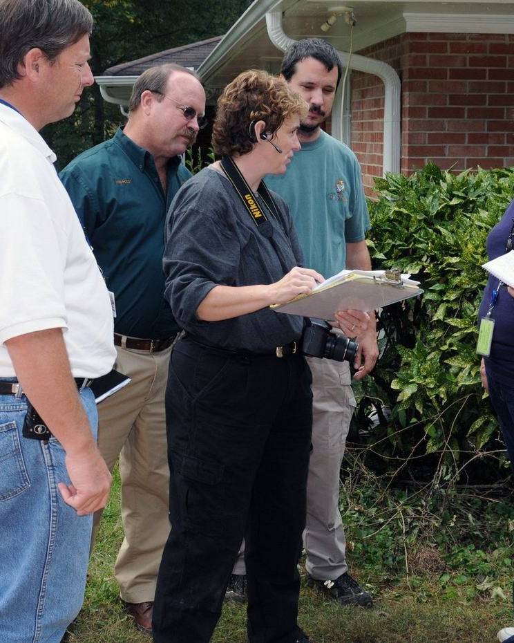 An inspection team reviews notes outside a damaged home in Georgia