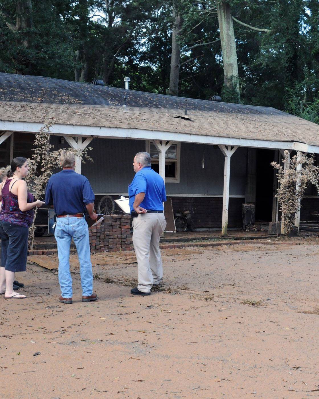 Assessors look over a flood-damaged house in Georgia