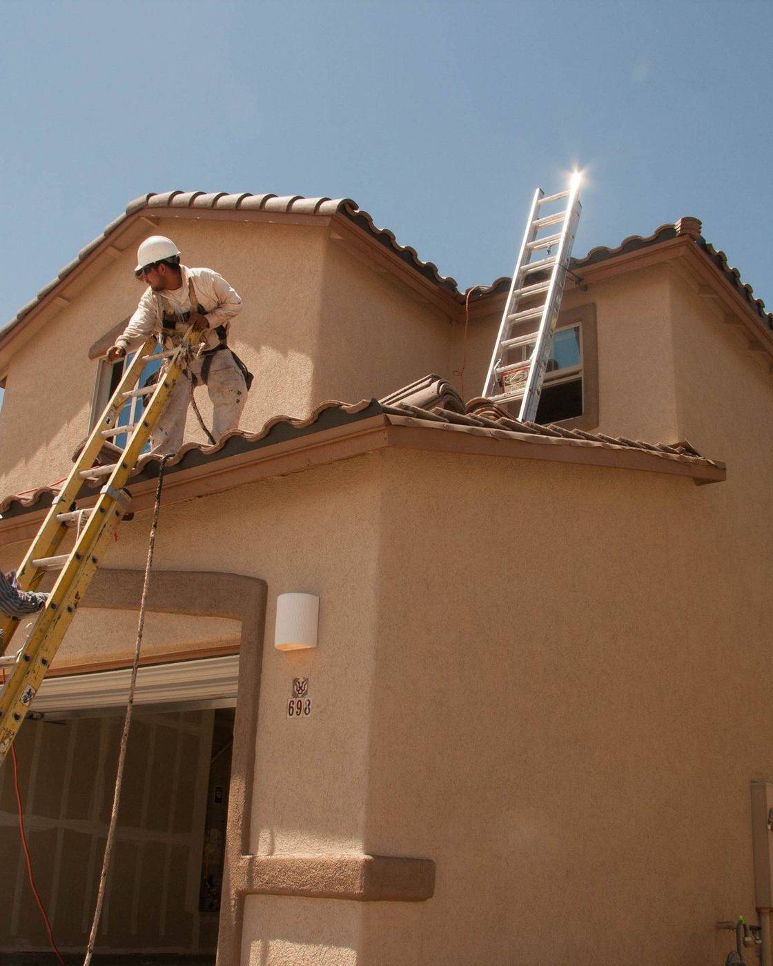 Builders working on the roof of a house under construction