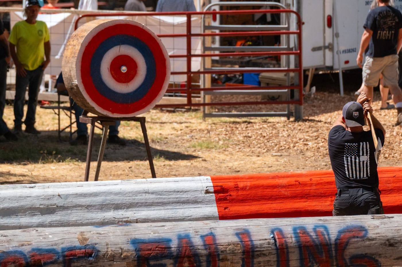 An axe thrower aiming at a round wooden target