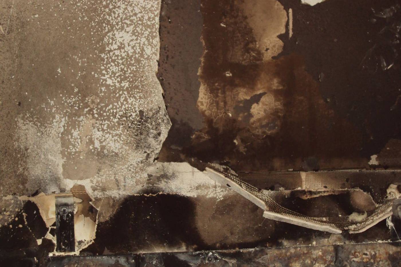A wall charred and blistered by fire